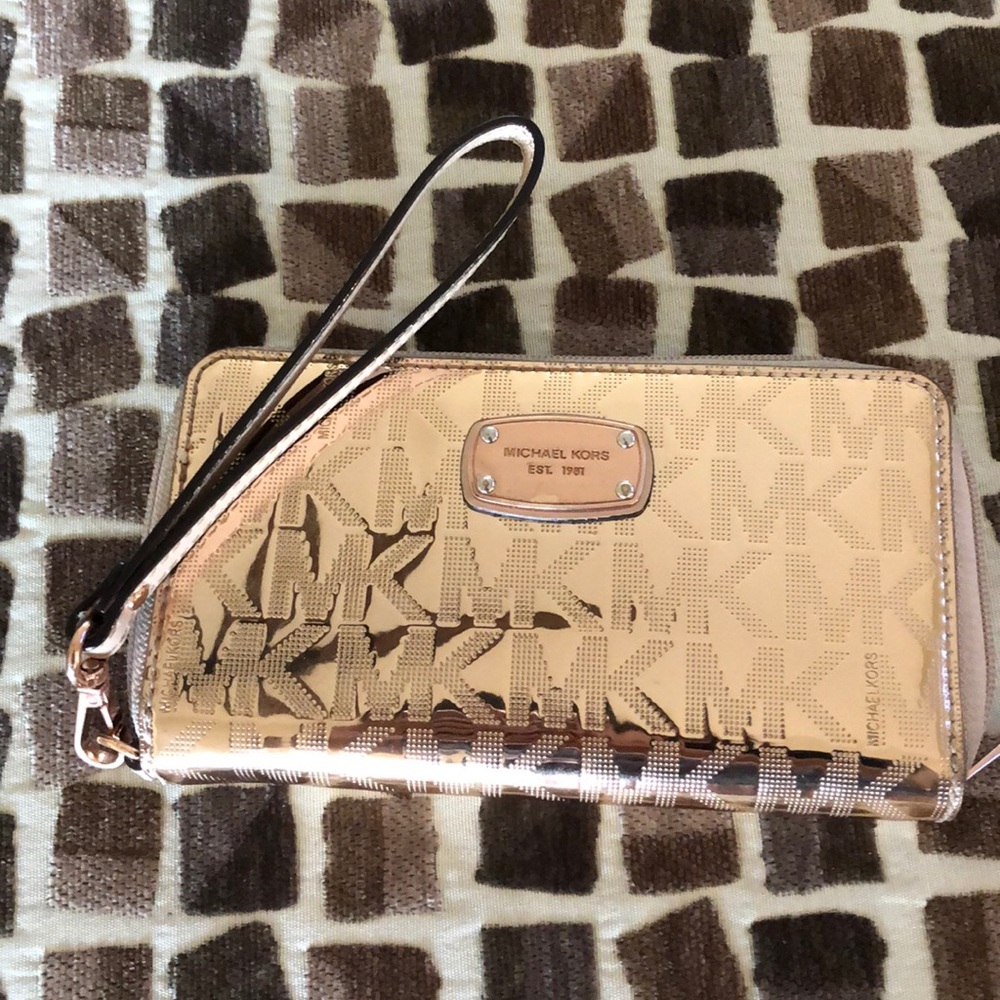 A rose gold metallic Michael Kors wristlet.